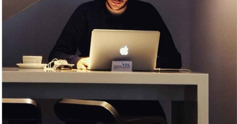 Cette image illustre un homme travaillant derrière son ordinateur sur l'analyse chiffrée de son activité