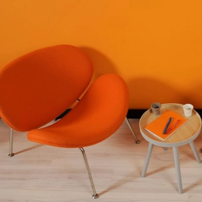 Photos d'une chaise orange et d'une table basse pour illustrer les prestations marketing de Sacheen Sierro