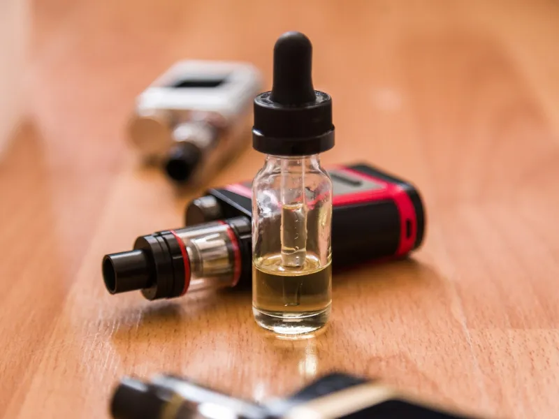 photo d'une e-cigarette et de plusieurs goûts pour illustrer l'analyse de la concurrence